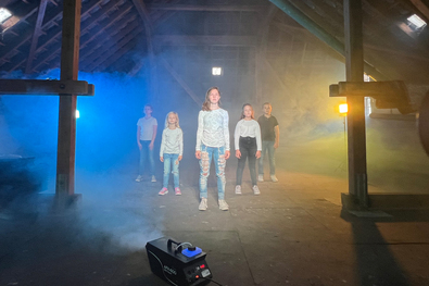 Kinder und Jugendliche bei der Aufnahme eines Musikvideos in einer alten Scheune.