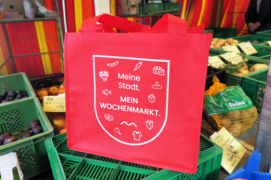 Eine rote Mehrwegtasche mit dem Aufdruck "Mein Wochenmarkt"