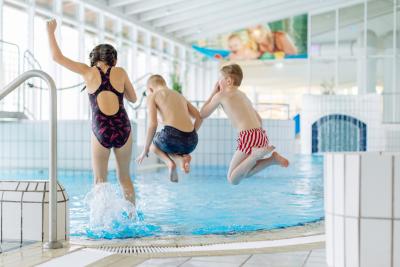 Springende Kinder Kinder springen ins Wasser